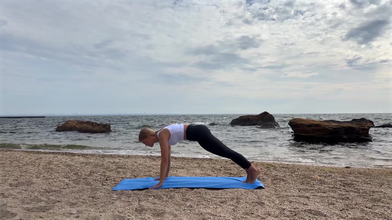 Young Woman Practicing Yoga on the Beach