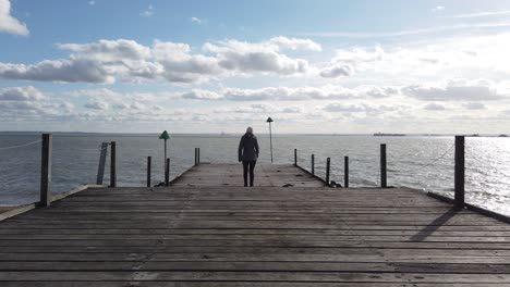 Señora-Caminando-Hasta-El-Final-Del-Embarcadero-En-Southend-On-Sea-Uk-Handheld-Gimbal-Día-Soleado-Con-Nubes