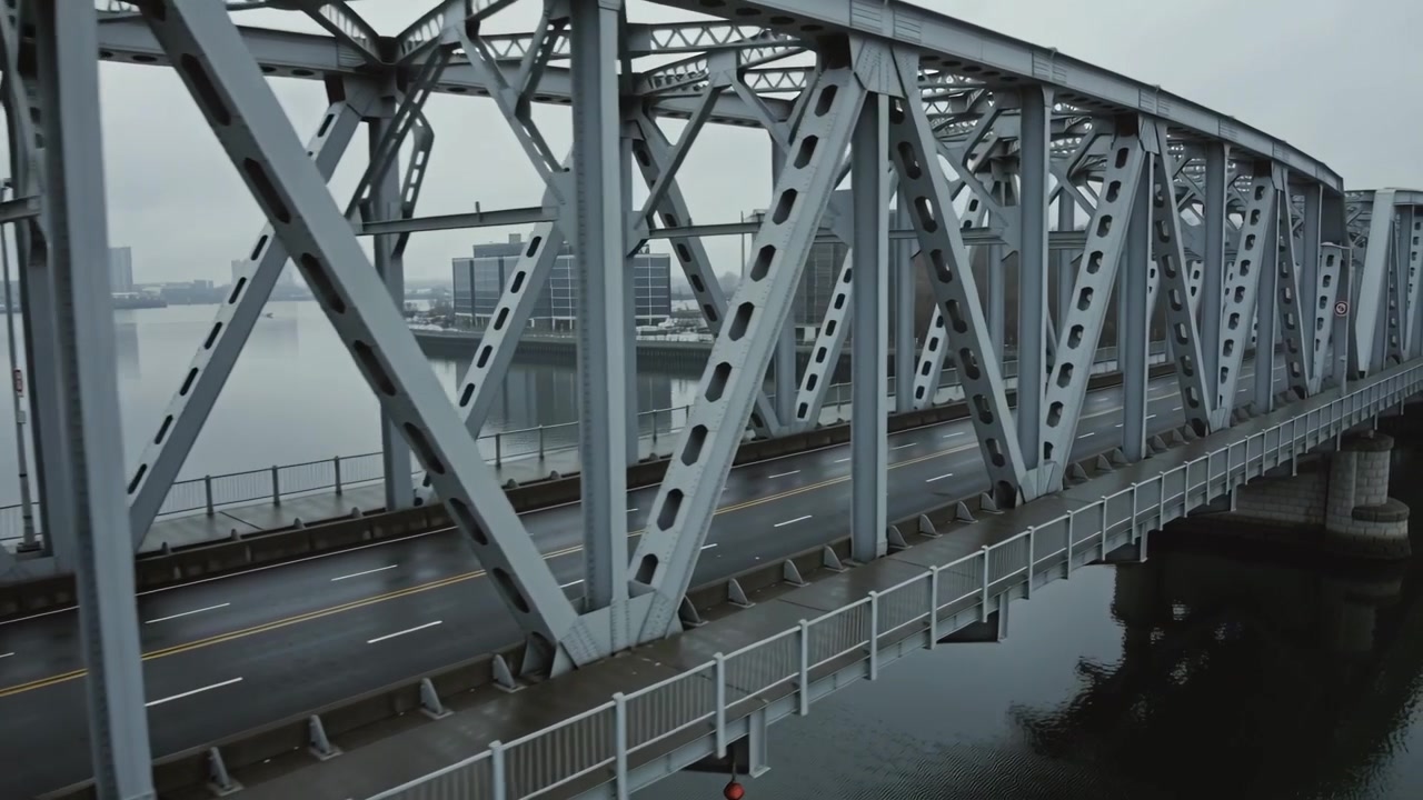 Panning camera revealing steel truss bridge over harbor, highlighting trusses with red lifebuoy
