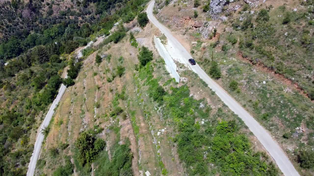 Car driving through a narrow road in Kadisha valley Lebanon - aerial shot