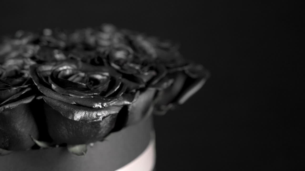 Black roses flower arrangement spinning on black background slider shot dark feeling