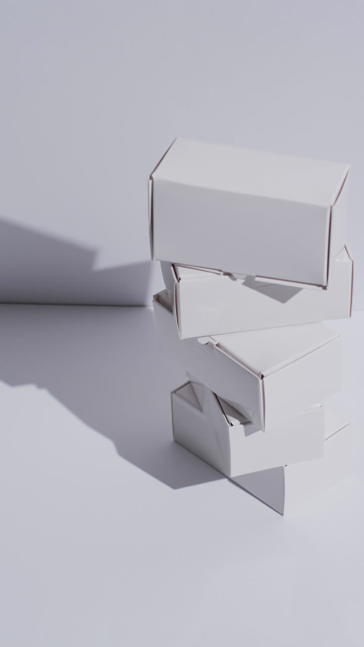 Vertical video of stacked cardboard boxes with copy space over white background