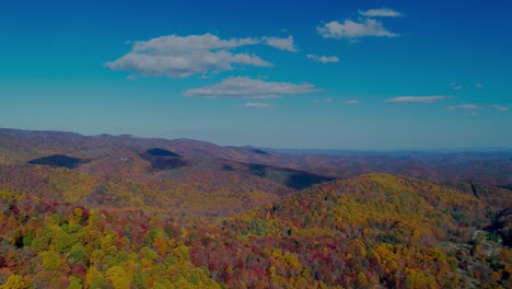 drone hyperlapse over autumn colored leaves in the mountains with clouds rolling by