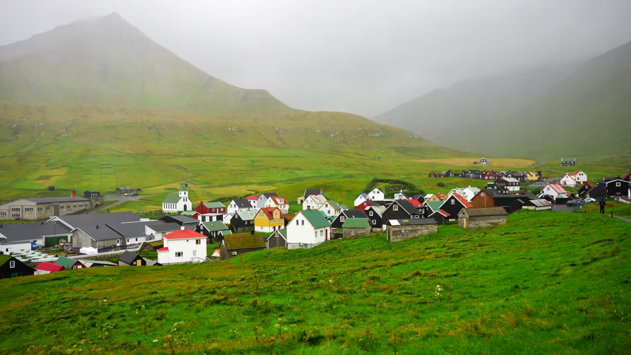 페로 제도의 gjogv 마을을 촬영하고, 배경은 안개 산입니다.