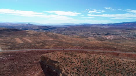 aerial drone shot over a plateau in the desert with a busy road