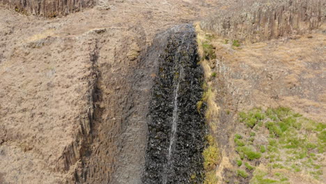 rising aerial over small waterfall, almost dried out, dry summer season, tabletop mountain