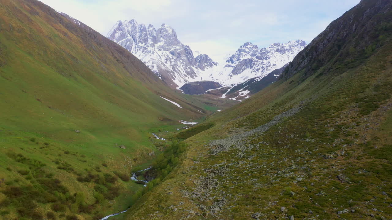 Ripresa cinematografica con drone che si muove lentamente verso le montagne innevate del Caucaso in Georgia