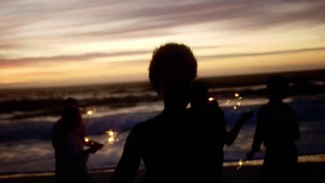 friends playing with sparklers on the beach 4k