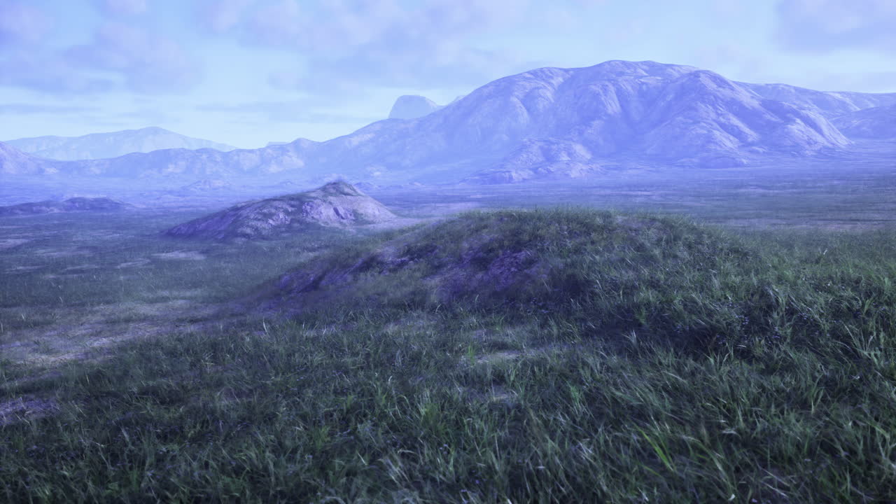 Vast grasslands stretch beneath towering mountains in a serene landscape