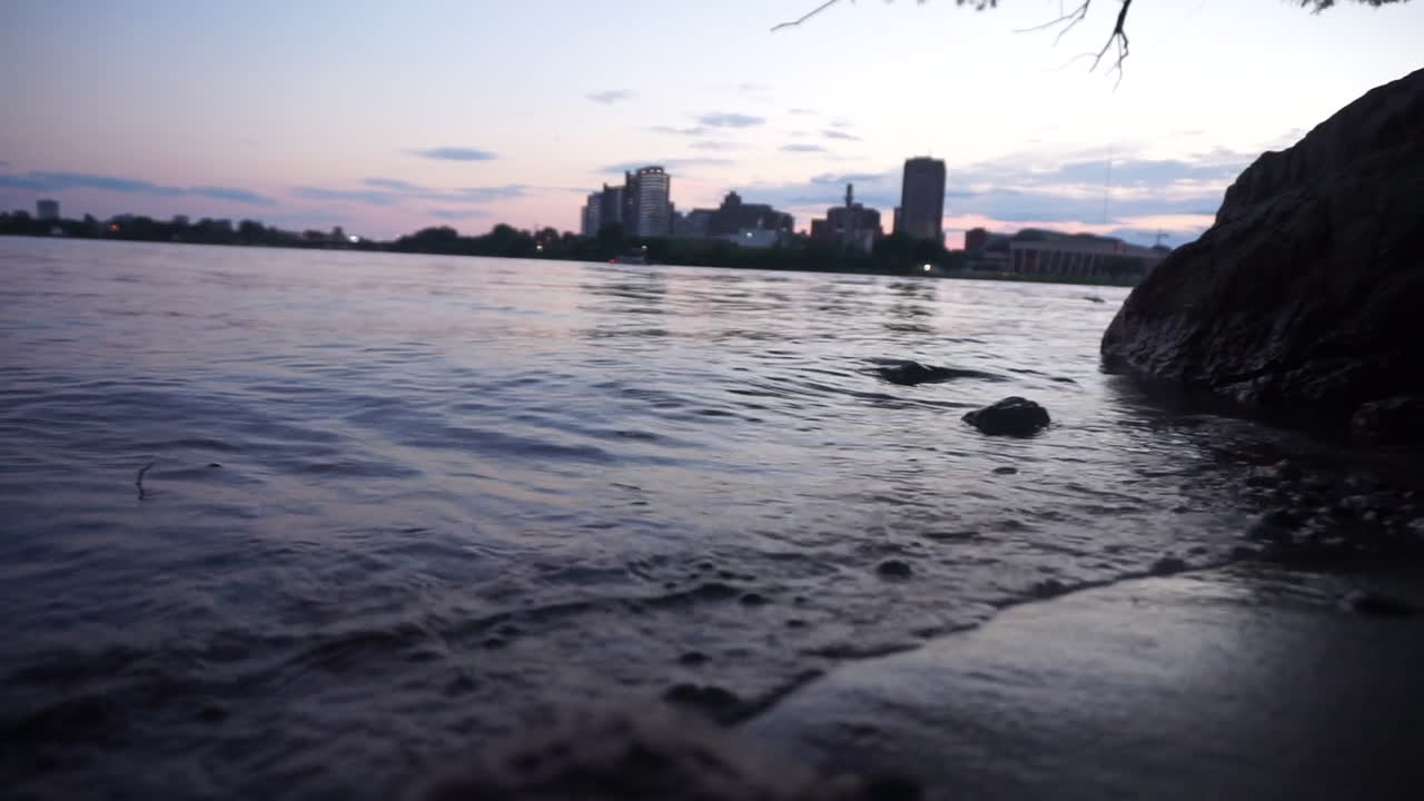 Small waves on the shore of the Ottawa River with city in the background.