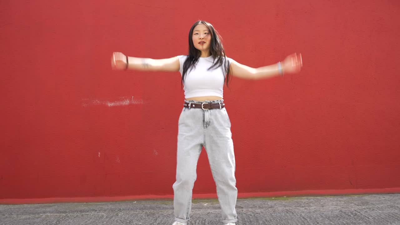 Woman dancing in front of a red wall