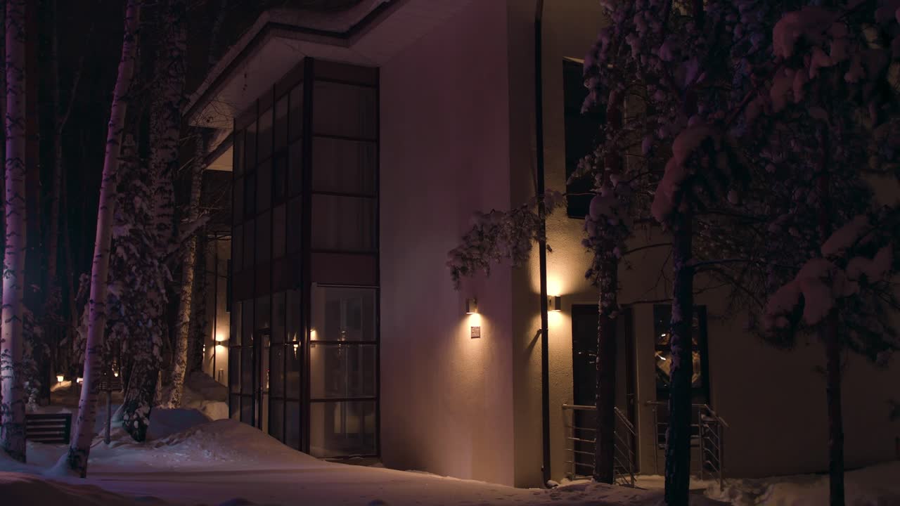 Snöig vinternatt vid modern bostadsbyggnad