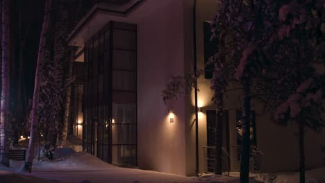 snowy winter night at modern residential building