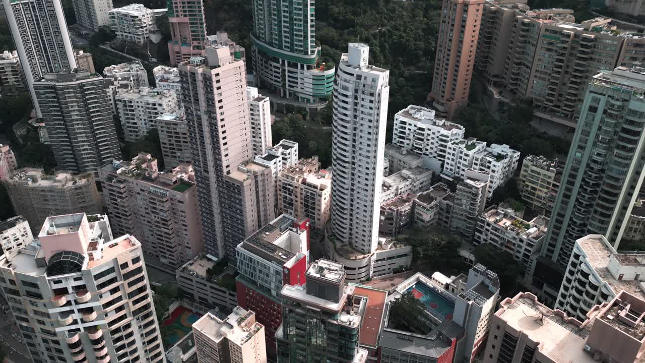 Filmagem aérea panorâmica de drone de edifícios e arranha-céus no centro de Hong Kong em um dia ensolarado, destacando o horizonte denso e a arquitetura urbana moderna