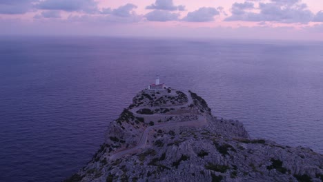 Wide-shot-of-lighthouse-Faro-de-Formentor-during-sunrise-at-Mallorca,-aerial