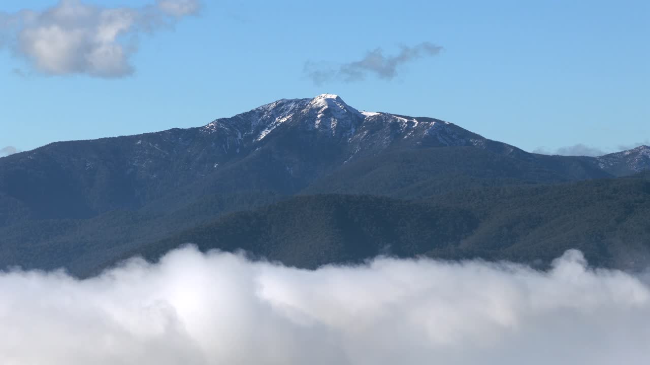 Mt Buller in the distance above the clouds on a beautiful blue sky day