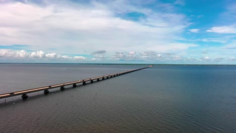 vista aérea volando cerca del agua mirando el puente mid-bay que conecta destin con niceville florida