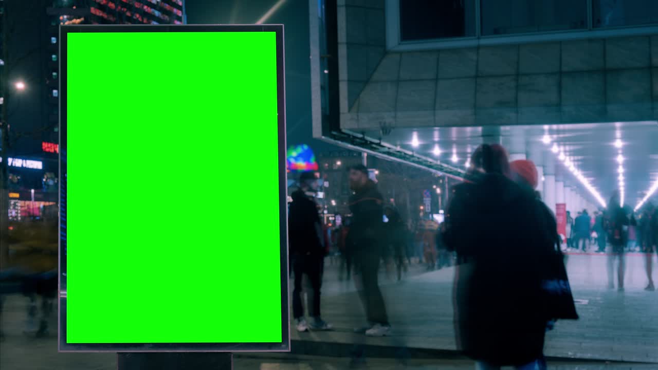 Grande cartellone pubblicitario con schermo verde per pubblicità su un edificio moderno con luci al neon, timelapse del traffico su un'autostrada trafficata, colori cyberpunk.
