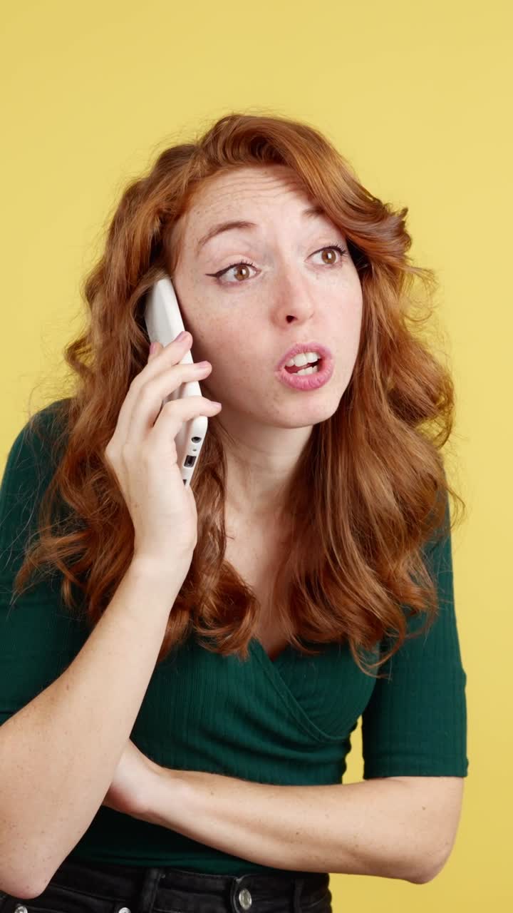 Donna dai capelli rossi che mostra preoccupazione al telefono