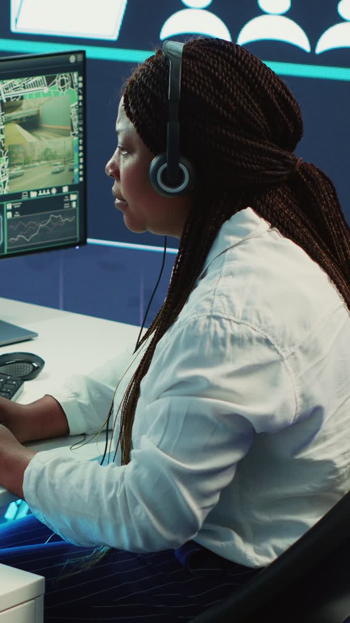 Focused Woman Monitoring Security Footage on Computer in Control Room