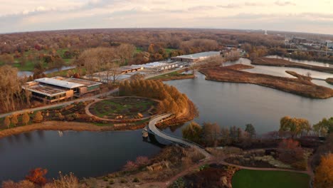 glencoe, illinois, usa : aerial drone forward moving shot over new building constructed inside chicago botanic garden with small lakes during evening time