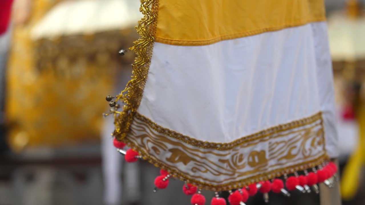 Intricately decorated banners of silk and colorful cloth blow in a gentle island breeze at a Hindu temple in Bali, Indonesia
