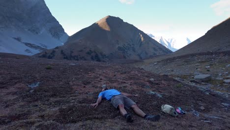 hiker laying down doing angels caressing in mountains pull away kananaskis alberta canada