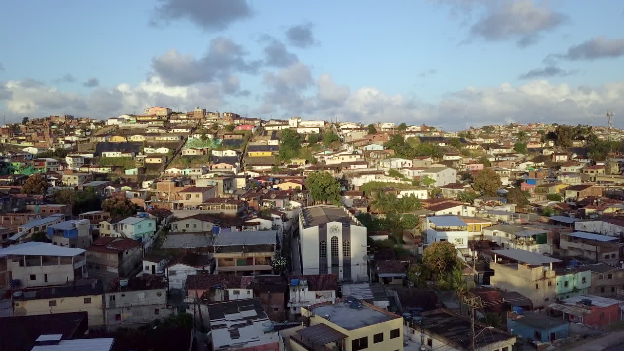 Aerial view of Macaxeira neighborhood in Recife Pernambuco Brazil showcasing a hillside community with simple houses cars and tarps highlighting poverty danger and social inequality during the day.