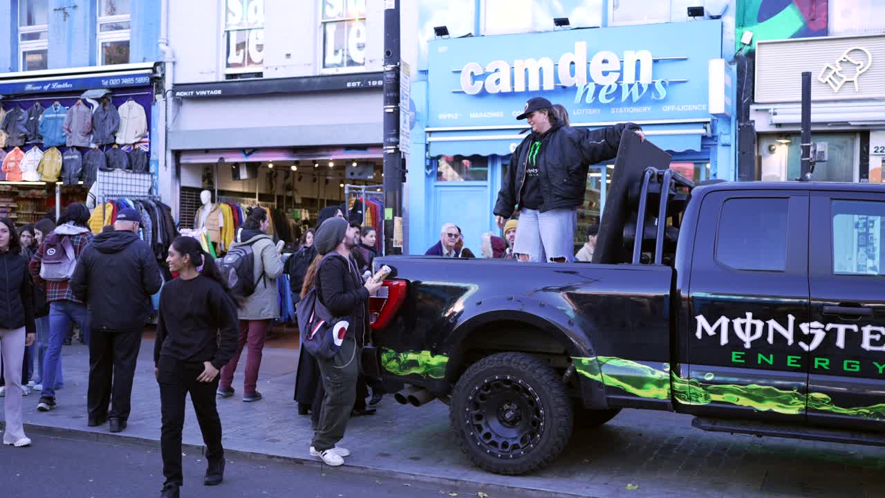Two ladies in a truck give away free Monster energy drinks at Camden Market in London, promoting the brand