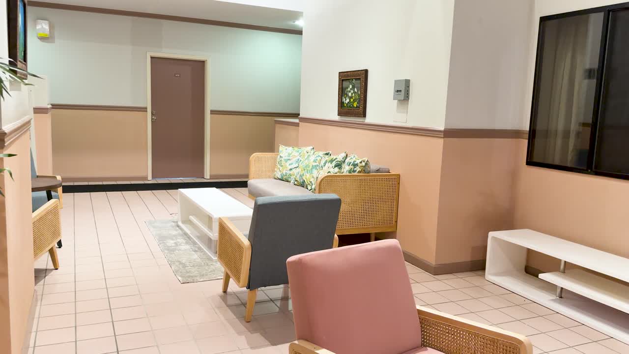 カラフルな家具と植物が配置された明るいリゾートラウンジをゆっくりとパンするショット。