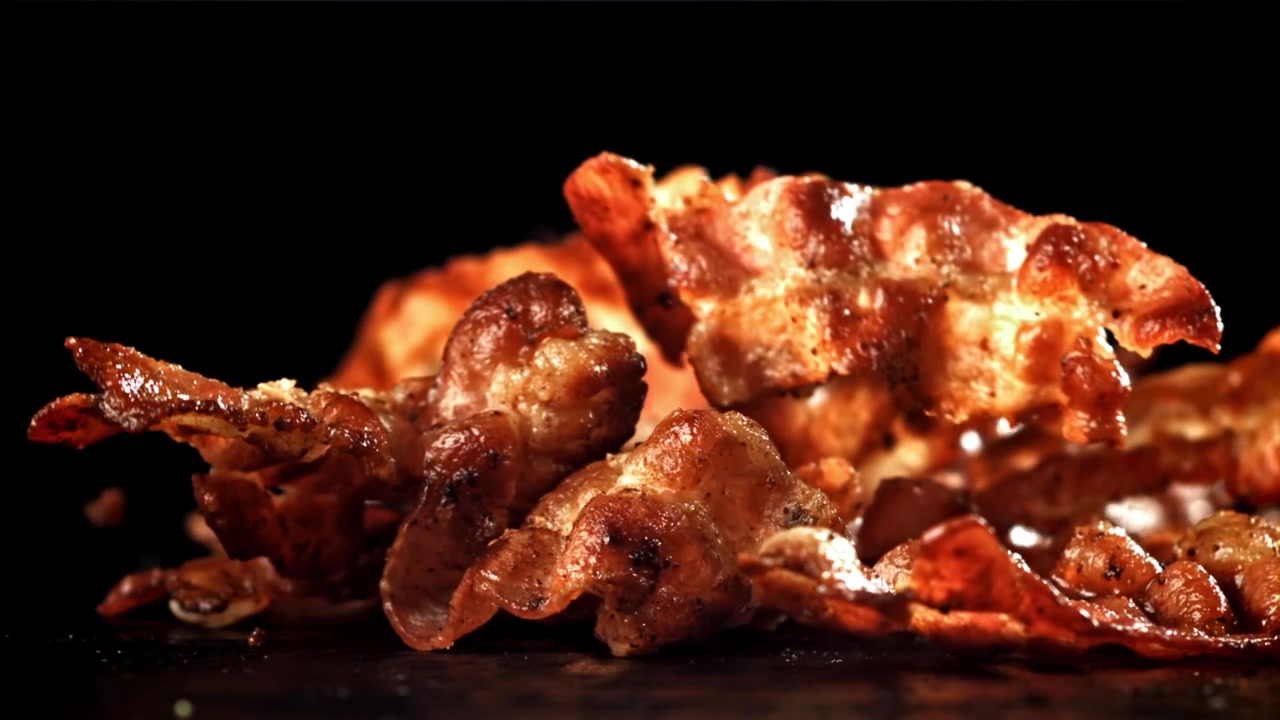 Strisce di bacon fritto croccante che cadono al rallentatore