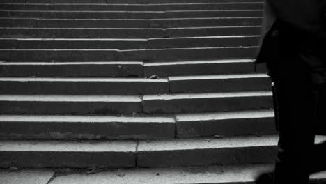 a man in a suit with a skull mask sits on steps