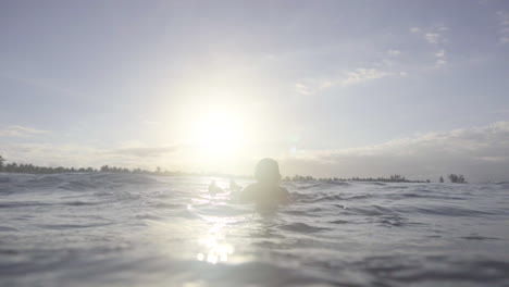 silhouette of asian surfer waiting for waves