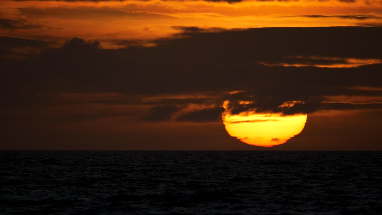 Beautiful stock video of a sunset over Aberystwyth, Wales, capturing the golden hour glow, scenic coastline, and tranquil ocean waves in a breath-taking evening view.