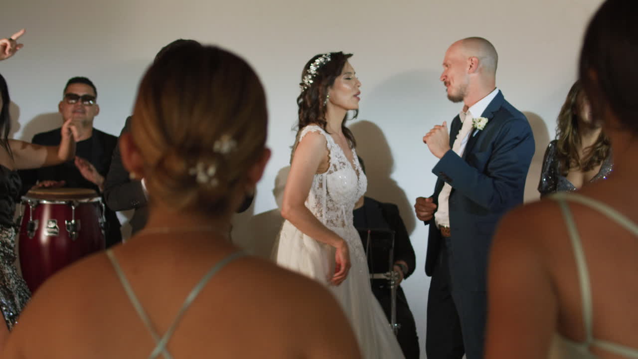 Clip of a wedding where the newlyweds dance happily with their guests and bridesmaids.