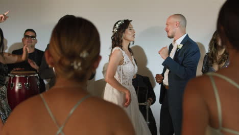clip of a wedding where the newlyweds dance happily with their guests and bridesmaids.
