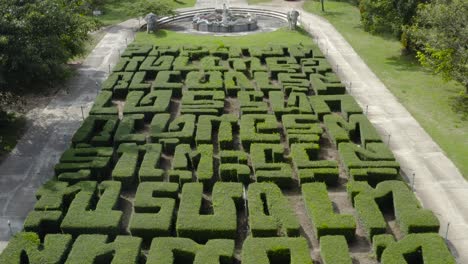 Eine-Wunderschöne-Drohnenaufnahme,-Die-Aus-Büschen-Aufsteigt-Und-Thailändische-Sätze-Buchstabiert,-Zu-Der-Treppe,-Die-Zu-Einem-Tempel-Führt