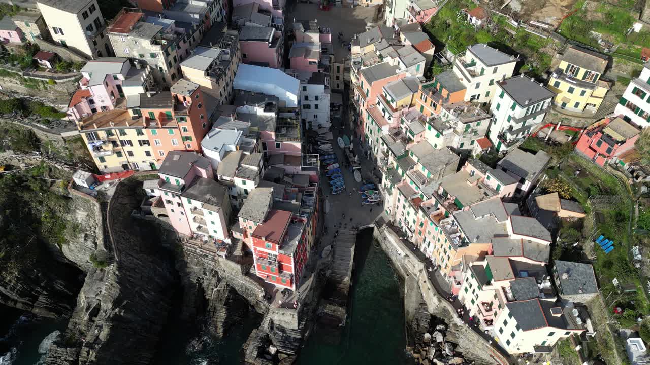Riomaggiore Cinque Terre Italy aerial rotating pullback shows boats parked downtown