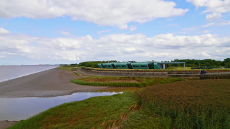 witness the waters' edge country park and visitor centre against the striking silhouette of the humber bridge in this aerial video