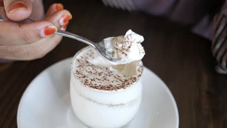 una mujer comiendo un tiramisu.