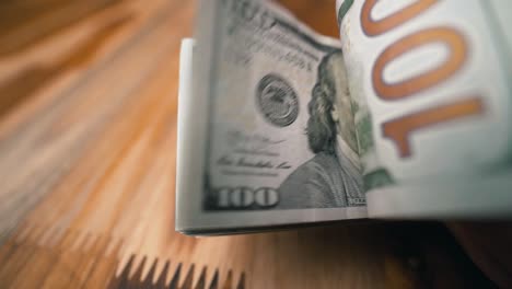 flipping a stack of one hundred dollar bills extreme close-up shot