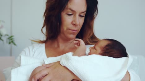 Front-view-of-Caucasian-mother-holding-her-newborn-baby-in-the-ward-at-hospital