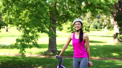 chica en forma va a dar un paseo en bicicleta en el parque