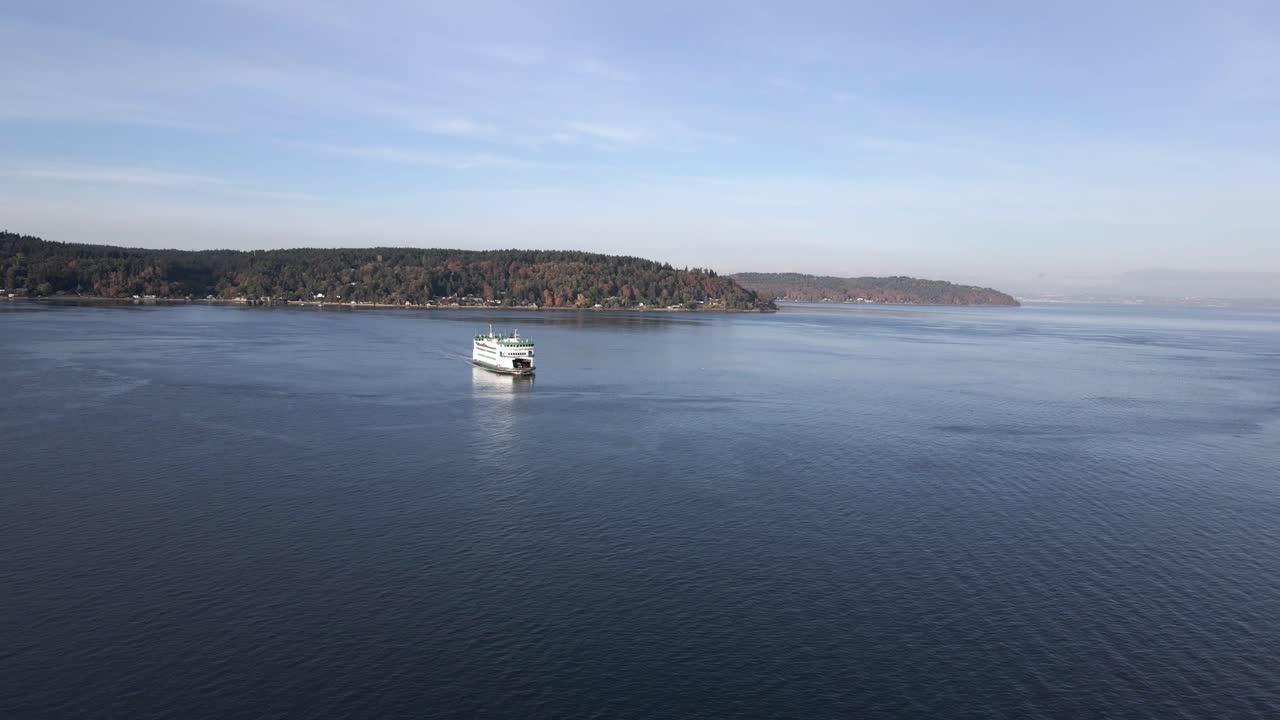 Gran angular de un transbordador blanco brillante cruzando una vía fluvial, agua azul tranquila, acercamiento aéreo