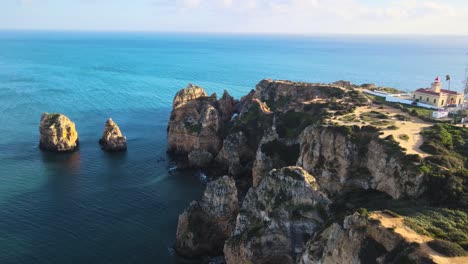 Fliegen-über-Die-Zerklüfteten-Klippen-Der-Halbinsel-Sagres-Point-Mit-Dem-Roten-Und-Gelben-Leuchtturm