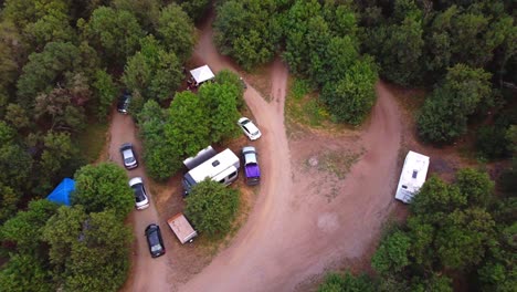 Drohne-Fliegt-über-Natur-Wildnis-Im-Freien-Nationalwald-Campingplätze-Mit-Autos-Und-Wohnmobilen-Und-Atv-Quad-4-Wheeler-Fährt-Einen-Unbefestigten-Pfad-Hinunter,-Während-Die-Kamera-Folgt,-Um-Herauszupeitschen