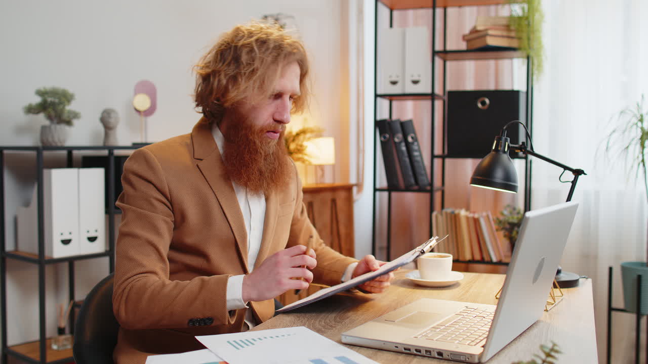 Caucasian redhead freelancer man accountant working with financial graph documents calculate taxes