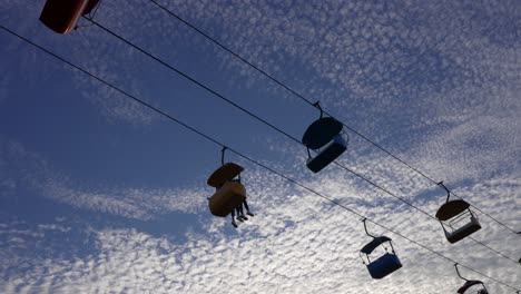 a hanging gondola lift crosses the evening sky at amusement park