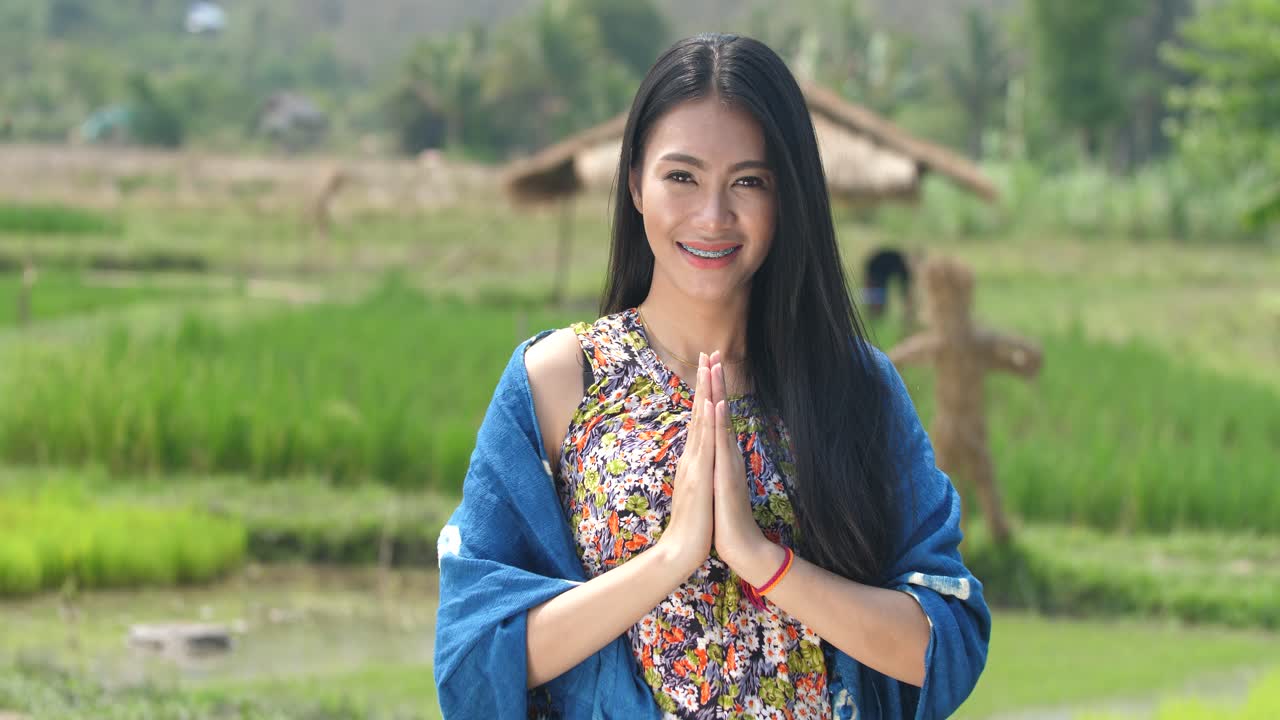 Smiling Thai Woman in Traditional Dress, Greeting in Rice Paddy