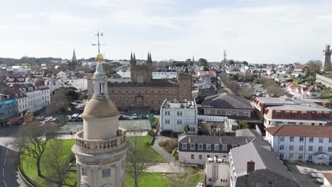 Flight-by-tower-of-St-James-Assembly-Hall-towards-Elizabeth-College-St-Peter-Port-Guernsey-on-bright-day